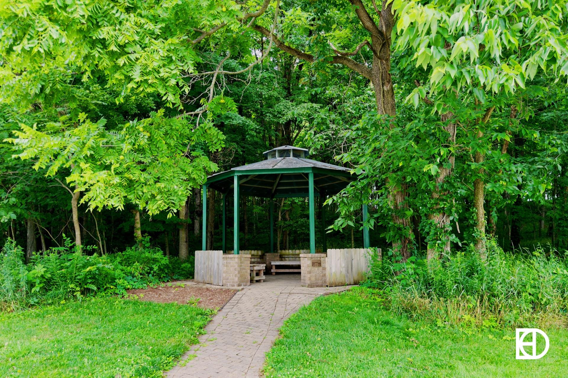 Exterior photo of MacGregor Park, showing shelter, paths, and trees