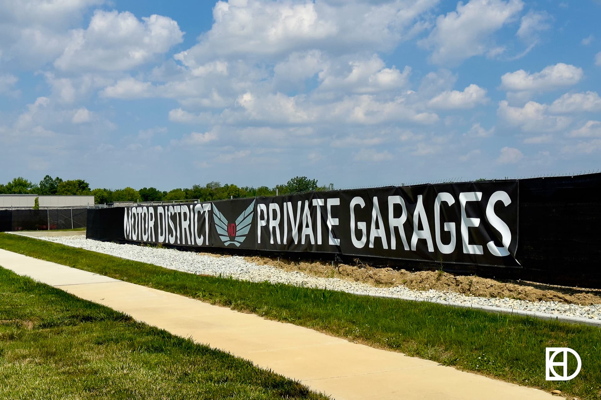 Neighborhood sign on fencing promoting Motor District Private Garages.