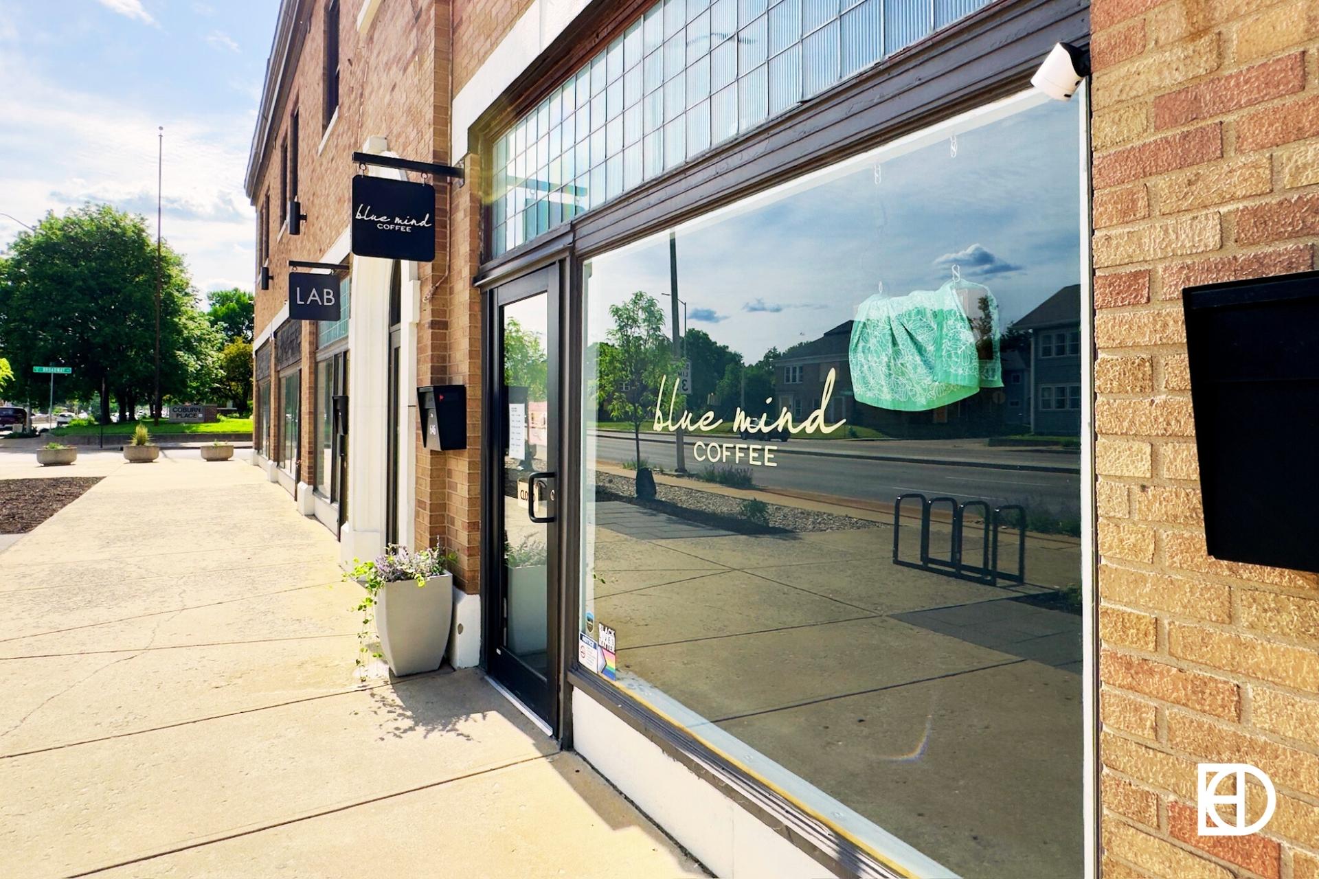 Exterior photo of Blue Mind Coffee, showing signage, entrance, and sidewalk