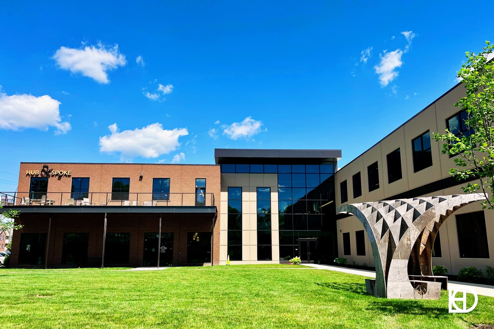 Exterior photo of Hub & Spoke, showing entrance and green space