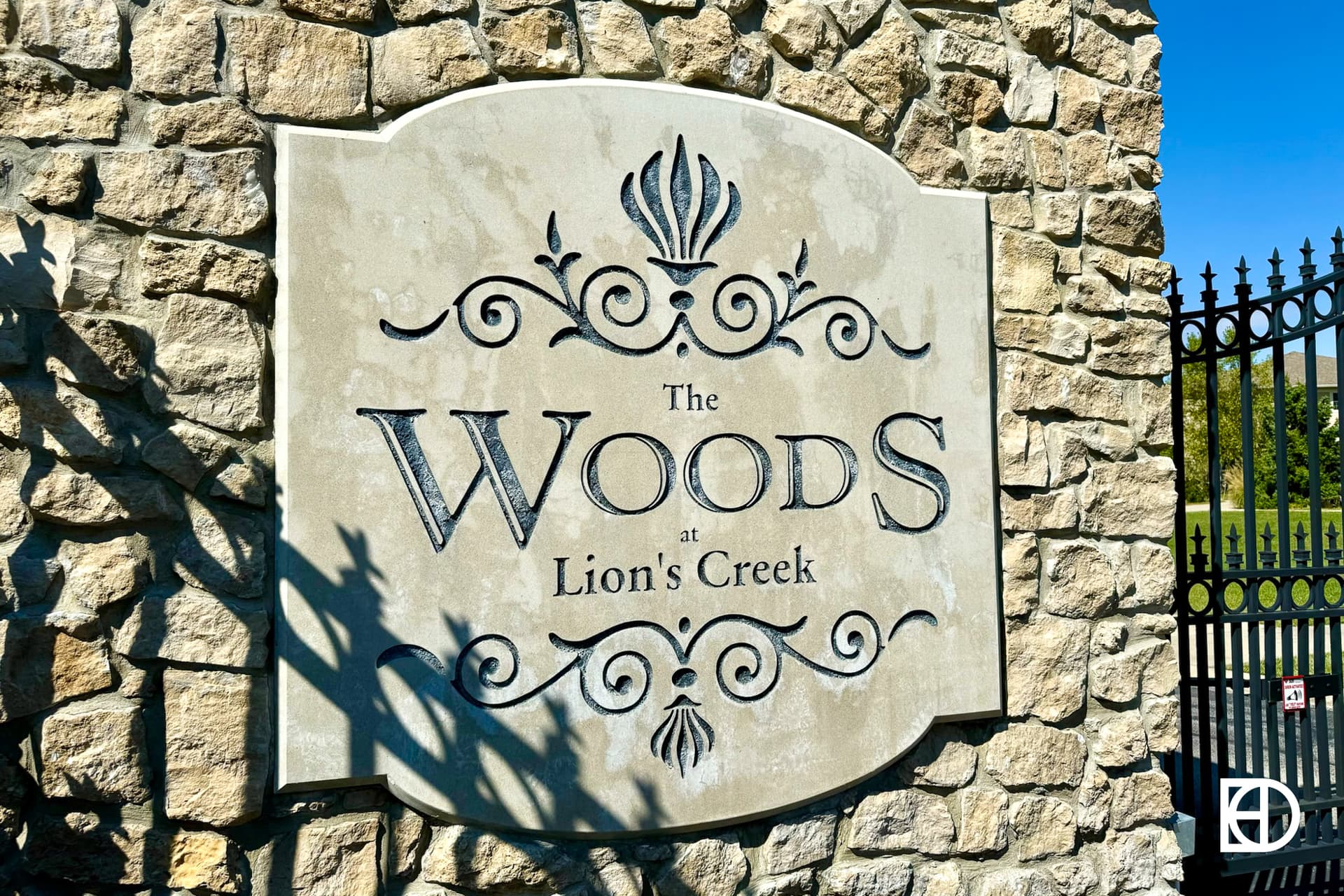 Exterior photo of Woods at Lion Creek, showing entrance and signage