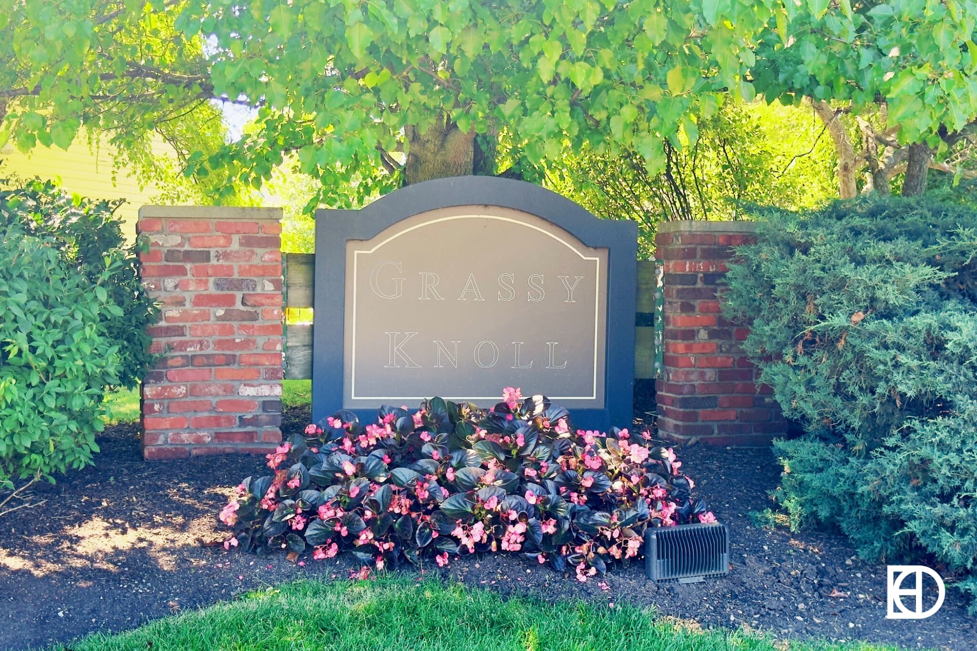 Exterior photo of Grassy Knoll, showing signage and landscaping