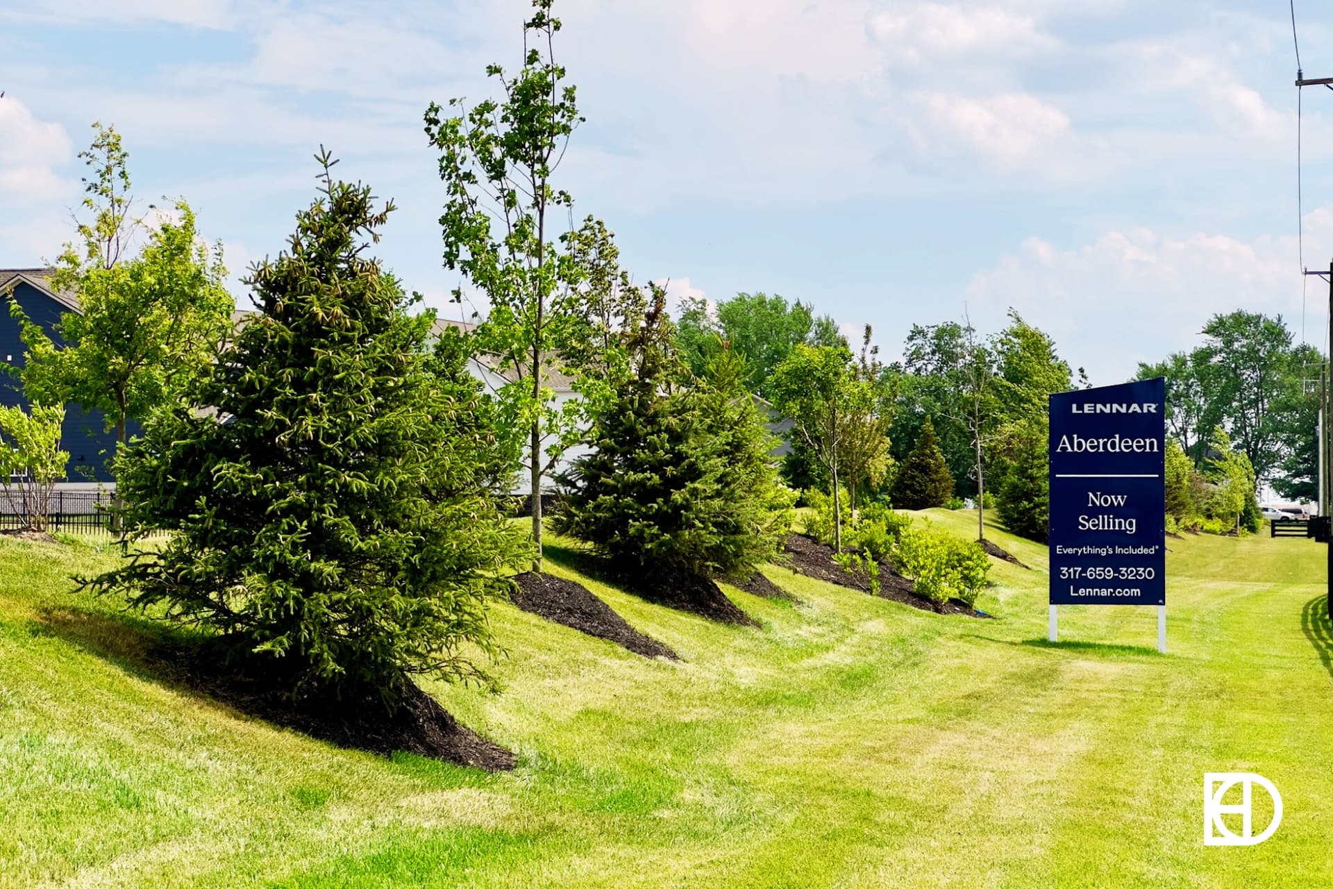 Photo of tree lined hill with Aberdeen neighborhood builder advertisement sign.